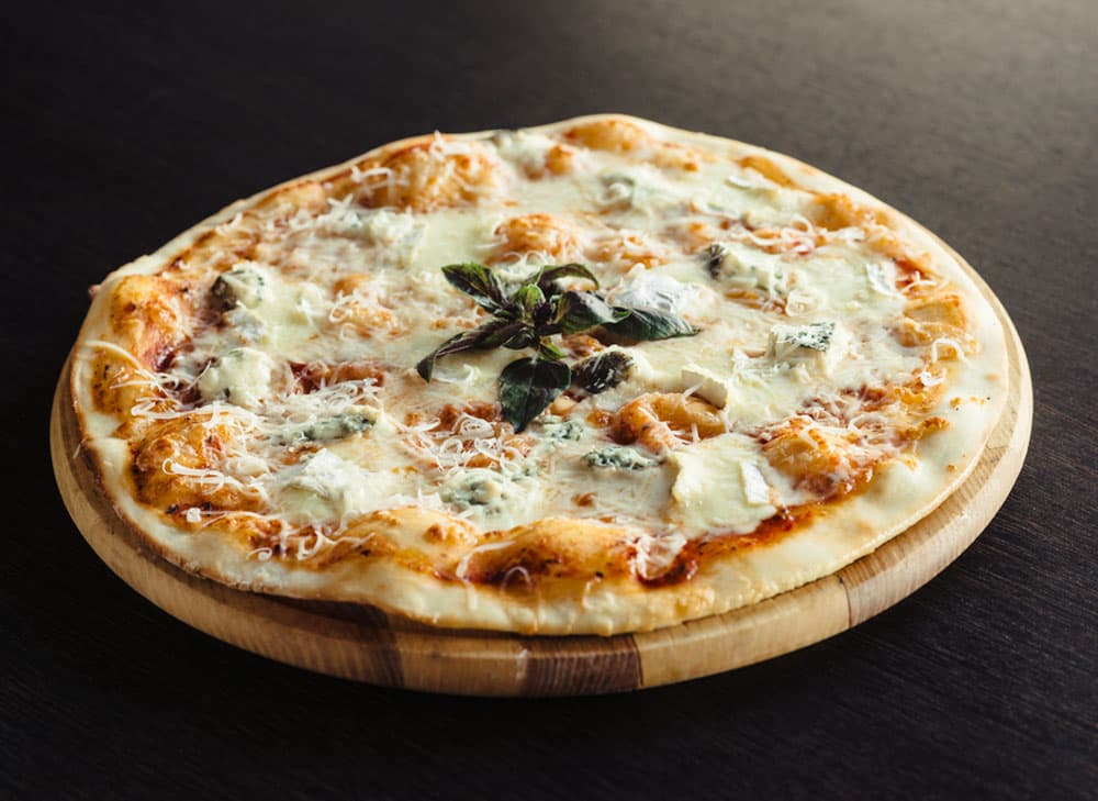 Garnissez votre pizza de 4 fromages : fromage vieux, pecorino, ricotta et gorgonzola.